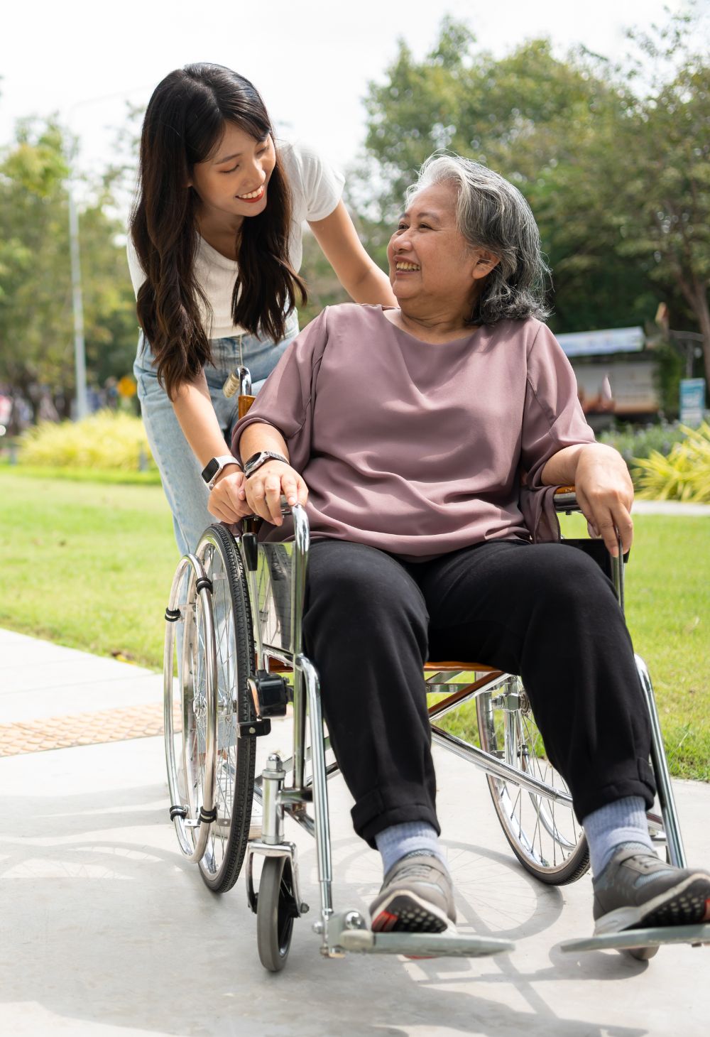 caregiver-walking-with-elderly ( A cheerful care giver pushes an elderly woman in a wheel chair.